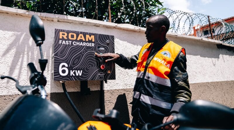 A motorcycle taxi rider using a ROAM fast charger in Kenya